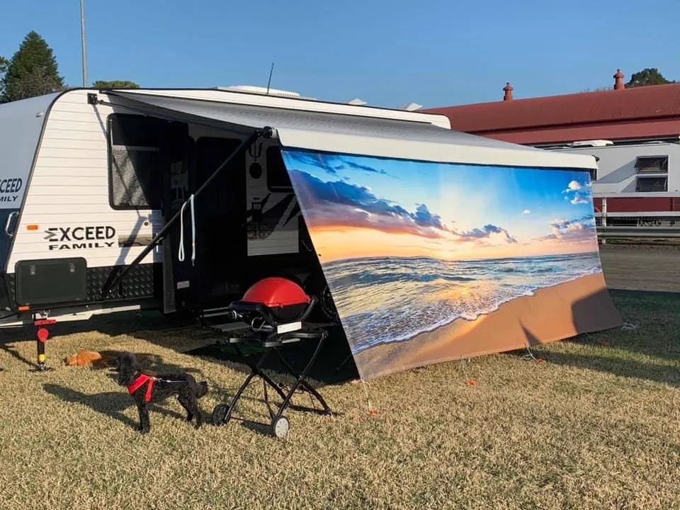 Caravan with a custom coastal sunset privacy screen